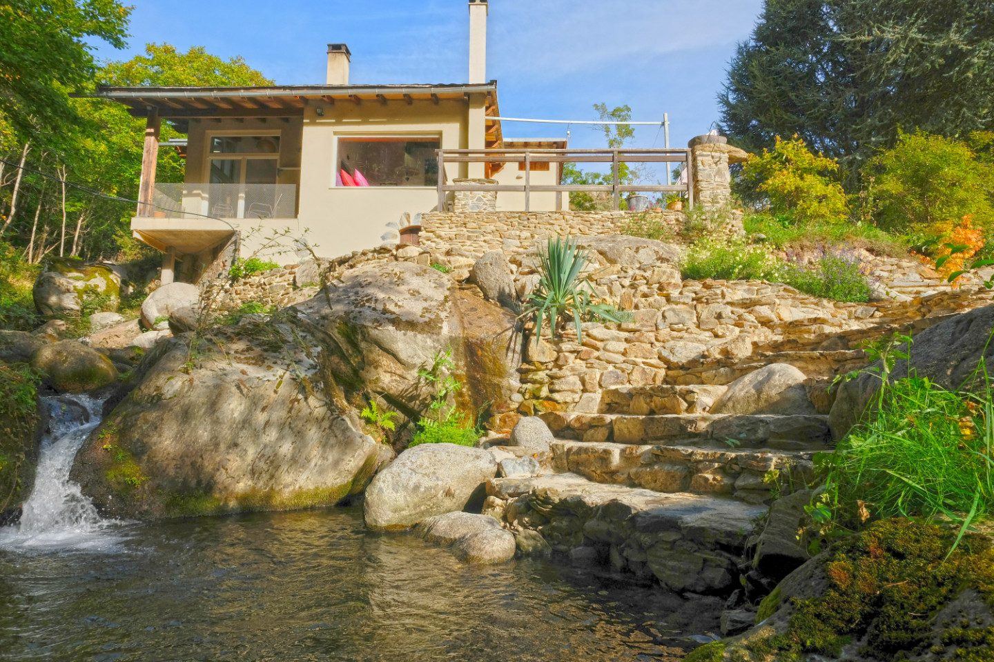 Le jardin, la cascade et le bassin naturel devant la maison